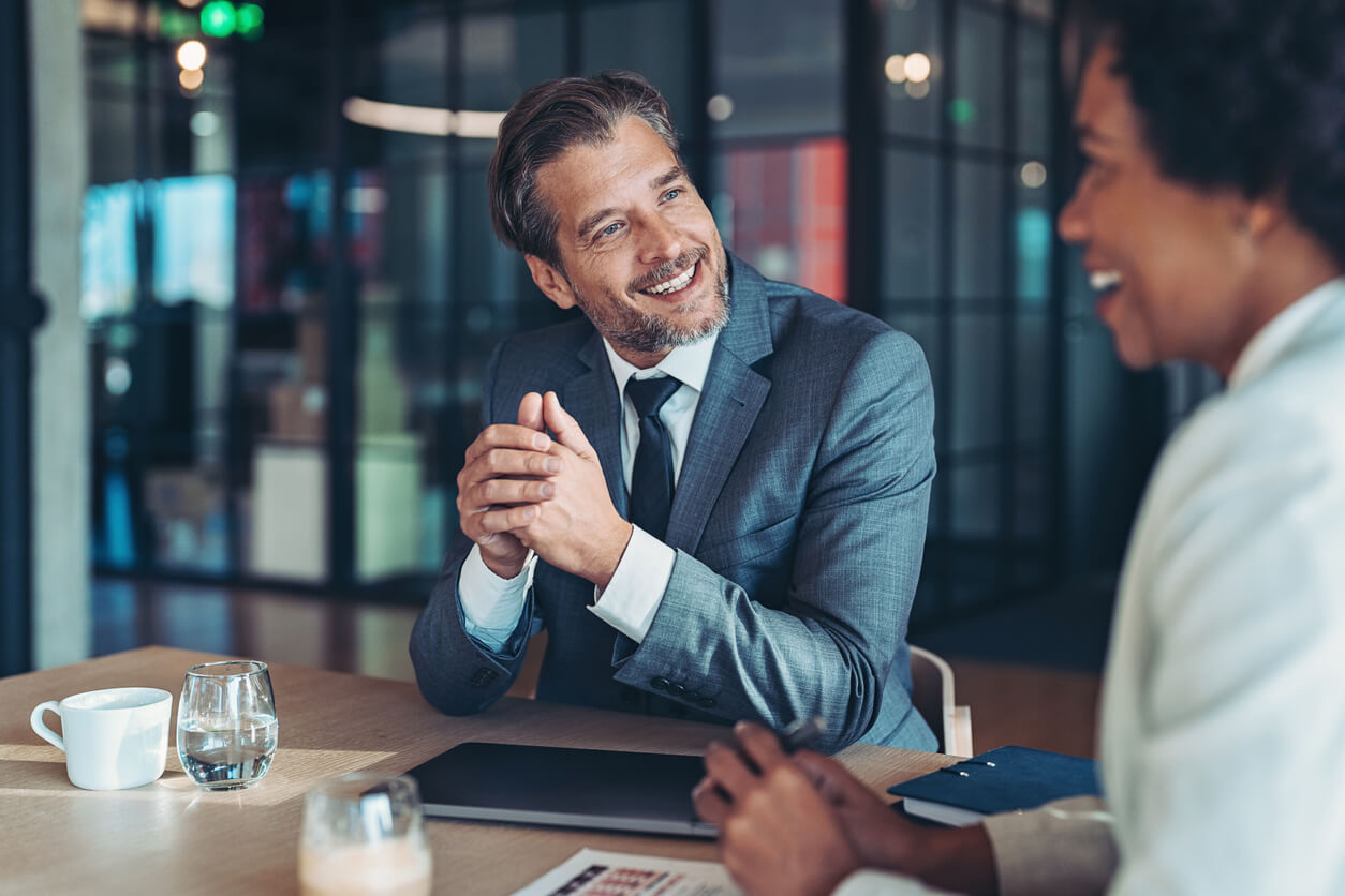 Two colleagues talking across a table in a bright office
